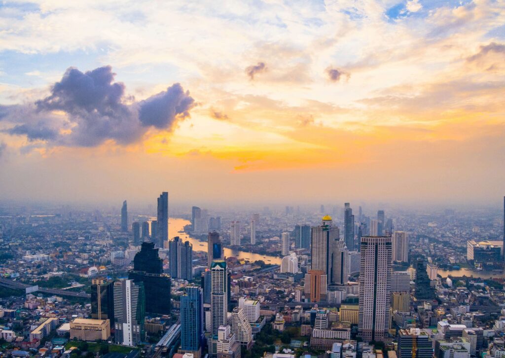 Bangkok skyline at sunset, showcasing vibrant colors and iconic buildings, representing the essence of a Bangkok vacation.